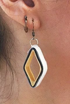 closeup of ear with large open square paper earrings 