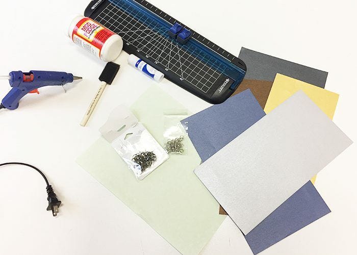 colored paper on white surface with hot glue gun, glue stick, paper cutter, etc