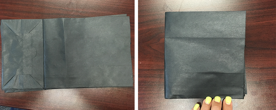 black kraft paper bag laid out on desk and folded in half