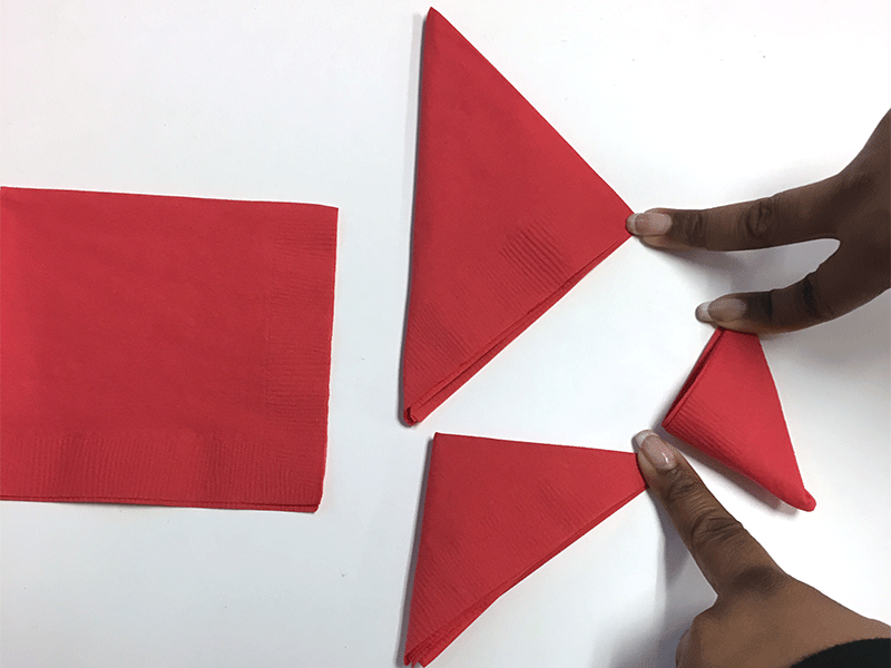 hands folding red napkins into triangles