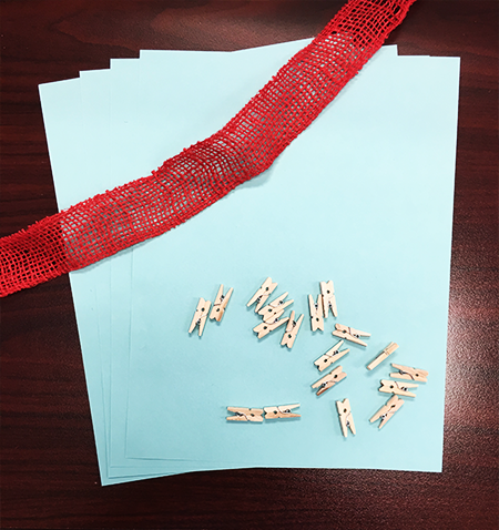 Red burlap, wooden clips, blue paper