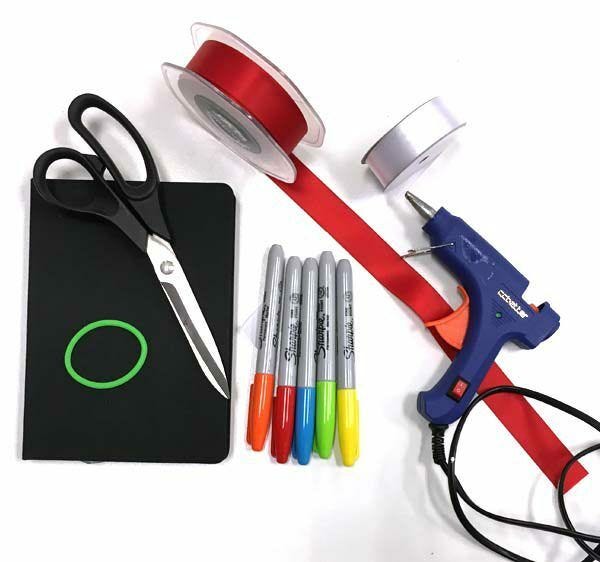 Supplies for DIY ribbon bookmark - glue gun, ribbon, scissors, elastic hair band, markers DIY ribbon supplies: scissors, ribbon, elastic hair band, markers, glue gun
