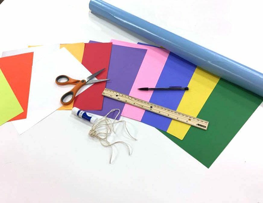 Materials for paper wall art - blue wrapping paper, colored paper, scissors, glue, twine, pencil, ruler