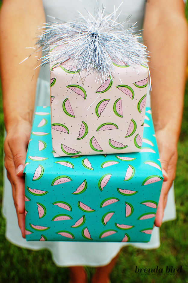 woman in skirt carrying two wrapped boxes with watermelon wrapping paper