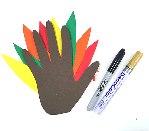 hand turkey with colorful feathers next to black sharpie pen and gold paint marker